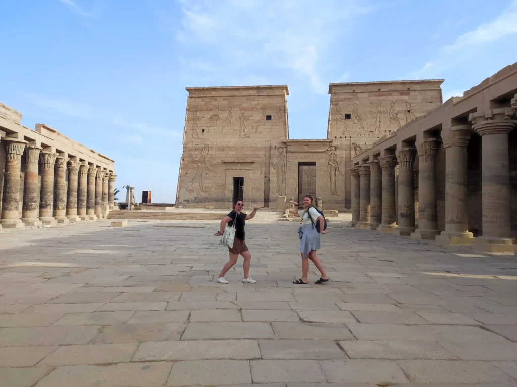 Due viaggiatrici davanti al Tempio di Philae ad Assuan durante l’escursione di un giorno da Marsa Alam in auto