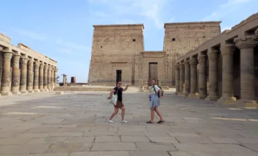 Due viaggiatrici davanti al Tempio di Philae ad Assuan durante l’escursione di un giorno da Marsa Alam in auto