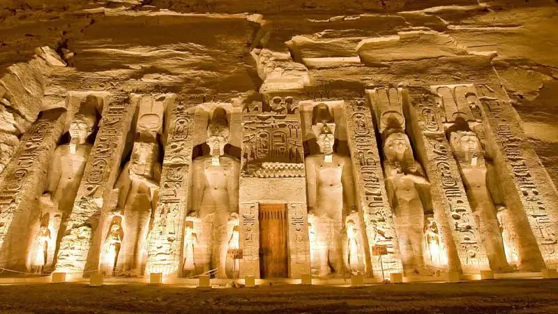 Facciata del Tempio di Nefertari ad Abu Simbel illuminato di notte con statue scolpite nella roccia durante l'escursione da Marsa Alam ad Assuan