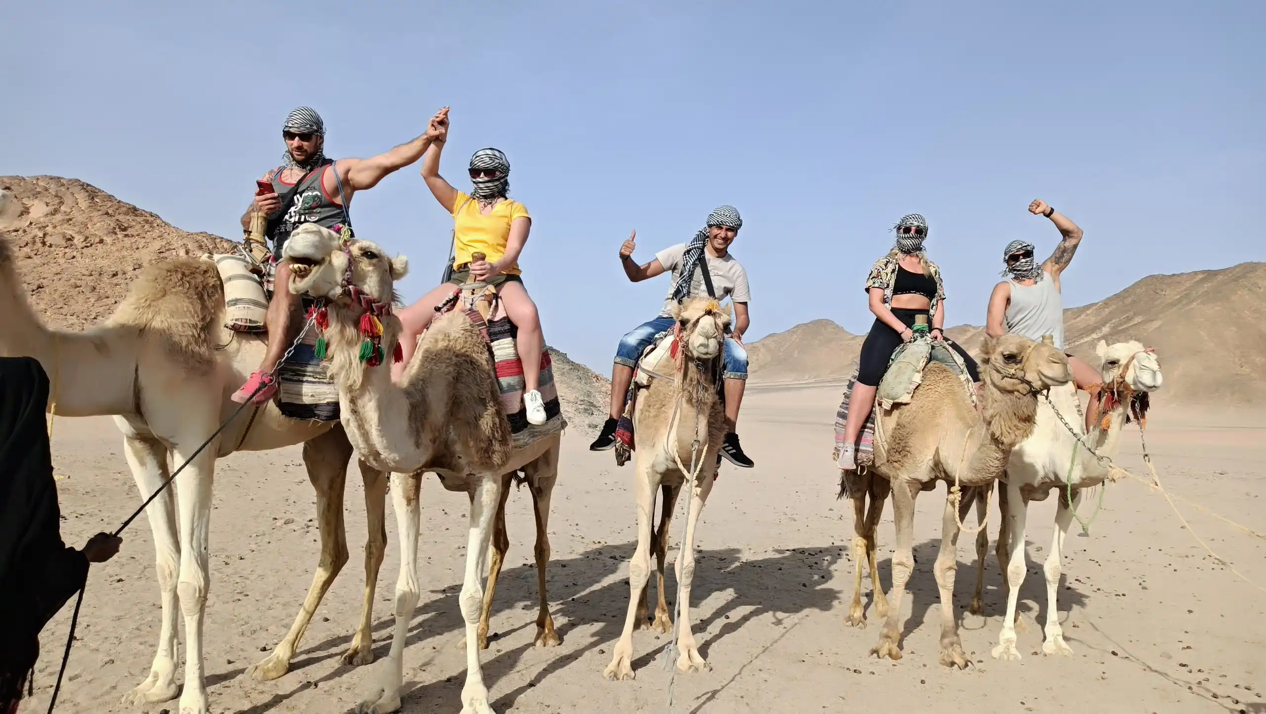 Wael di Egitto Unico guida un gruppo di turisti durante una cammellata nel deserto di Marsa Alam al tramonto