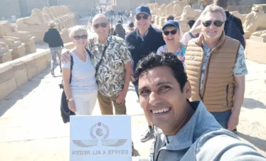 Gruppo di turisti con Wael Rasmy proprietario di Egitto Unico durante l’escursione privata da Hurghada a Luxor in auto di un giorno davanti al Tempio di Karnak