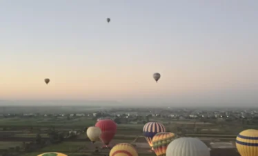 Mongolfiere colorate che sorvolano Luxor all’alba durante il giro in mongolfiera – Scopri i templi dall’alto con Egitto Unico di Wael Rasmy