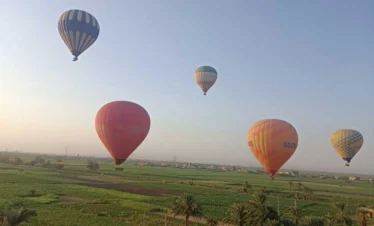 Colorate mongolfiere in volo sopra Luxor al sorgere del sole viste durante il tour di 2 giorni a Luxor da Hurghada in auto privata