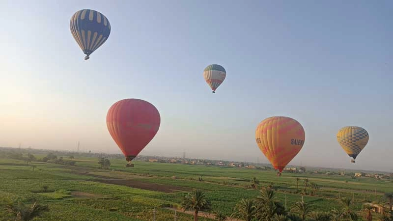 Colorate mongolfiere in volo sopra Luxor al sorgere del sole viste durante il tour di 2 giorni a Luxor da Hurghada in auto privata
