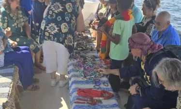 Turisti durante il tour in barca a vela con pranzo e visita al villaggio nubiano ad Assuan, acquistano gioielli e artigianato nubiano a bordo della barca