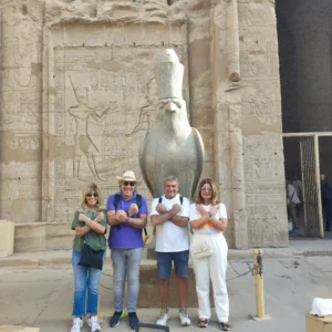 Gruppo di turisti davanti alla statua del dio Horus al Tempio di Edfu durante il tour in giornata a Edfu e Kom Ombo con partenza da Luxor