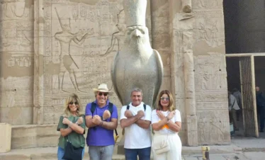 Gruppo di turisti davanti alla statua del dio Horus al Tempio di Edfu durante il tour in giornata a Edfu e Kom Ombo con partenza da Luxor