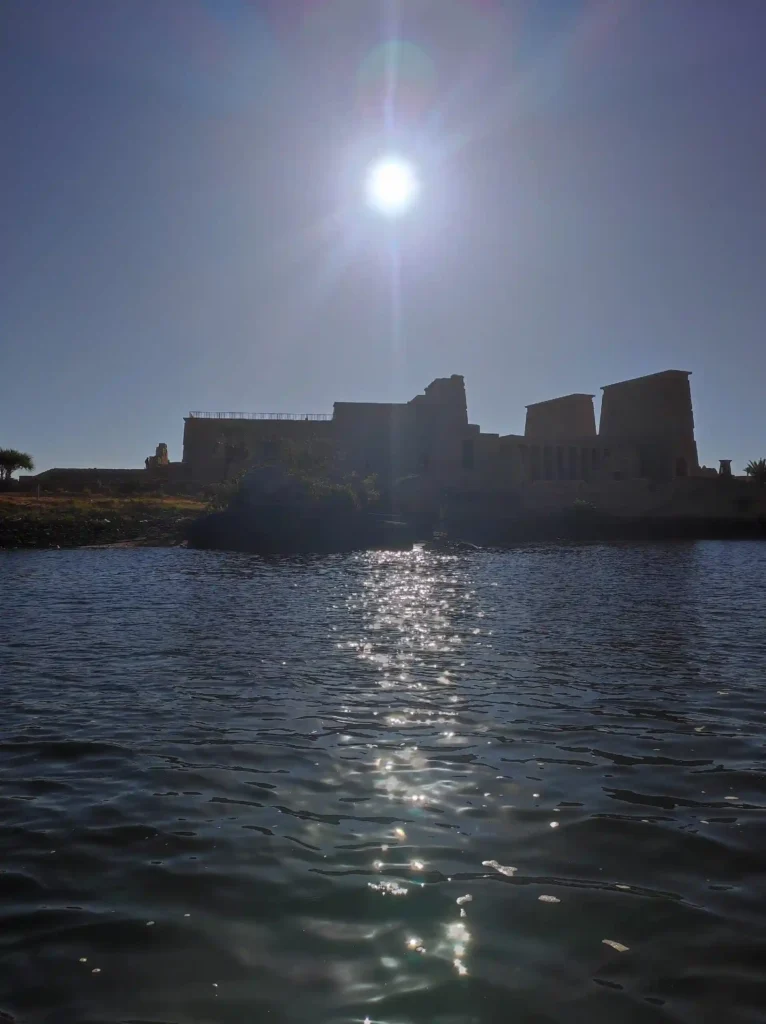 Tempio di Philae visto dal Nilo con il sole alto durante il tour di 3 giorni da Luxor ad Assuan e Abu Simbel senza fretta