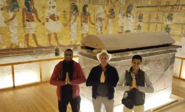 due turisti conWael Rasmy il proprietario di egitto unico nella Valle delle Regine, davanti a un sarcofago decorato, durante la Gita Valle delle Regine, Deir el-Medina e Ramesseum da Luxor.