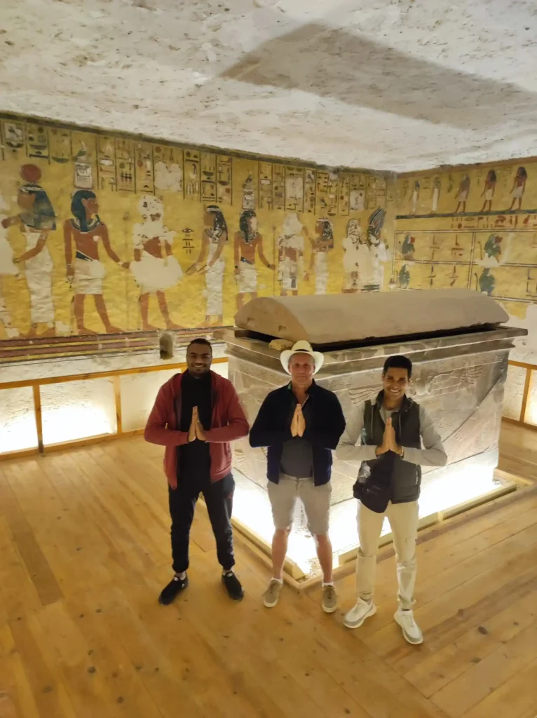 due turisti conWael Rasmy il proprietario di egitto unico nella Valle delle Regine, davanti a un sarcofago decorato, durante la Gita Valle delle Regine, Deir el-Medina e Ramesseum da Luxor.