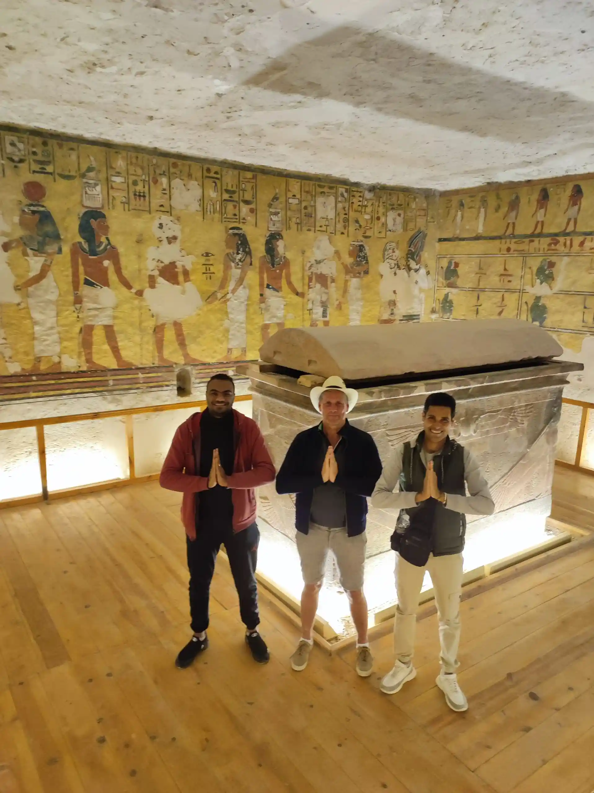 due turisti conWael Rasmy il proprietario di egitto unico nella Valle delle Regine, davanti a un sarcofago decorato, durante la Gita Valle delle Regine, Deir el-Medina e Ramesseum da Luxor.